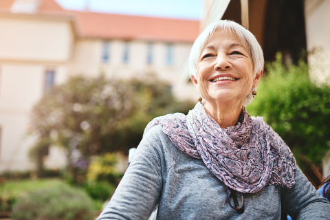 An older woman sitting down and smiling.