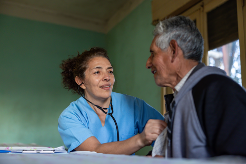 Rural doctor listening to the heartbeat of a patient at home.